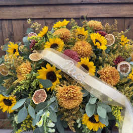 Large sunflower and chrysanthemum arrangement with a ribbon and dried citrus slices