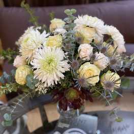 Bouquet of white and pale yellow flowers in a glass vase