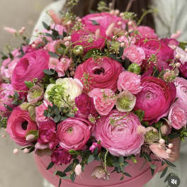 Pink ranunculus bouquet in a round pink box