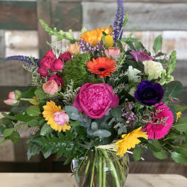 Mixed bouquet of bright flowers in a clear glass vase
