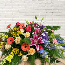 Colorful mixed flower arrangement with roses, lilies, and gerbera daisies