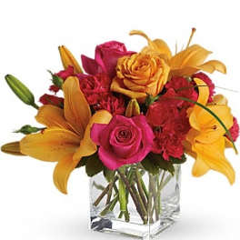 Pink roses and yellow lilies in a clear glass vase