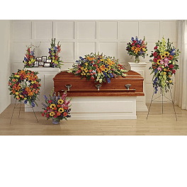 Casket surrounded by colorful funeral flower arrangements in a chapel setting