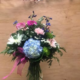 Mixed bouquet in a glass vase with blue hydrangea and pink flowers