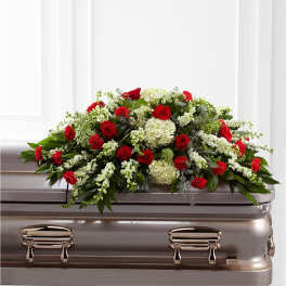 Red and white floral spray on a silver casket