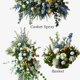 Floral casket spray, standing spray, and basket arrangement in white, yellow, and blue