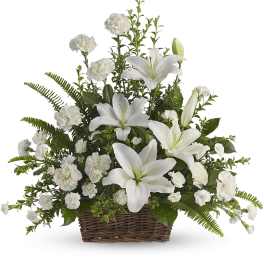 White lilies and carnations arranged in a wicker basket
