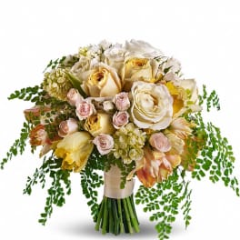 Hand-tied bouquet of cream and pale peach roses with yellow tulips and trailing ferns