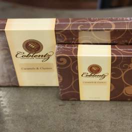 Two boxed chocolate gift sets with brown swirl packaging