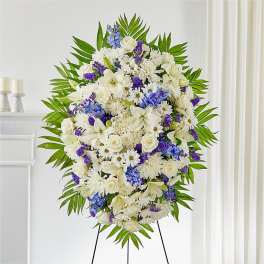 Large white and purple funeral spray on an easel
