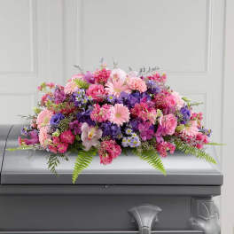 Pink and purple floral casket spray with mixed blooms