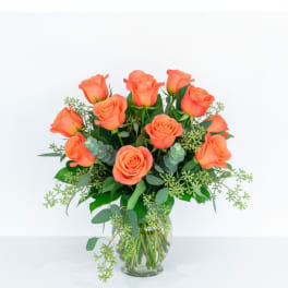 Orange roses arranged in a clear glass vase