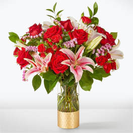 Bouquet of red roses and pink lilies in a glass vase