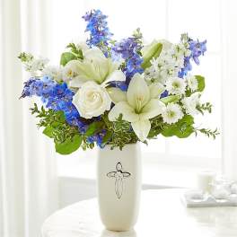 White lilies and roses with blue flowers in a white vase