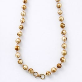 Gold beaded necklace on a white background