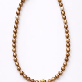 Gold beaded necklace on a white background