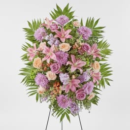 Standing floral spray with pink lilies, roses, and purple blooms
