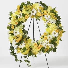Yellow and white floral wreath on a black stand
