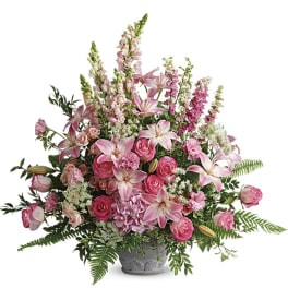 Large pink arrangement of lilies, roses, hydrangea, and snapdragons in a gray urn-style container