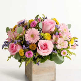 Pink roses and mixed pastel flowers in a wooden box