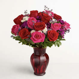 Bouquet of red and pink roses in a red glass vase