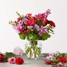 Mixed pink and red flower bouquet in a clear glass vase