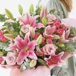 Pink lilies and roses in a hand-tied bouquet