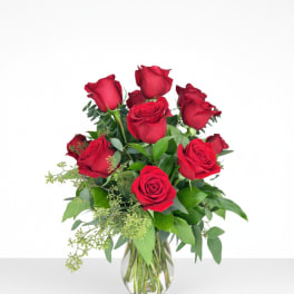 Red roses arranged in a clear glass vase
