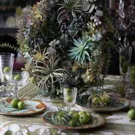 Large succulent centerpiece with air plants and eucalyptus on a table