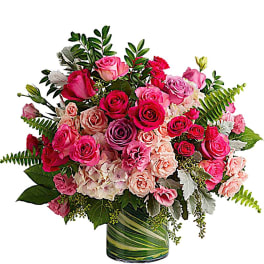 Bouquet of pink and peach roses in a green-striped glass vase