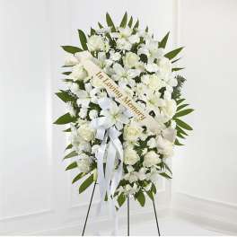 White sympathy wreath with ribbon on a stand
