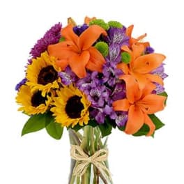 Vase of orange lilies, yellow sunflowers, and purple mixed flowers tied with twine