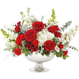 Red roses and white flowers arranged in a silver pedestal bowl