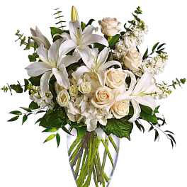 White lilies and cream roses in a clear glass vase