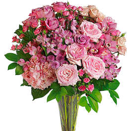 Pink rose and orchid bouquet in a clear glass vase