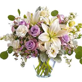 Lavender roses and white lilies in a clear glass vase