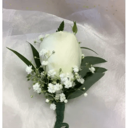 White rose boutonniere with baby's breath and dark green leaves