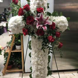Cross-shaped floral spray with white chrysanthemums, red roses, and a pink lily