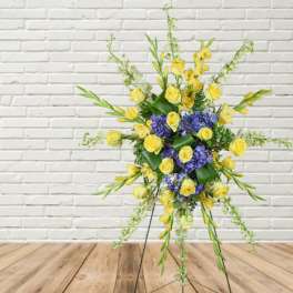 Yellow and blue floral standing arrangement on a metal easel