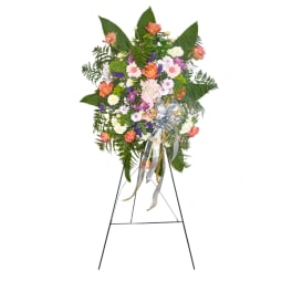 Standing floral spray with mixed pink, white, orange, and purple blooms on an easel