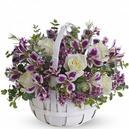 White basket of white roses and purple and white alstroemeria with small purple blossoms