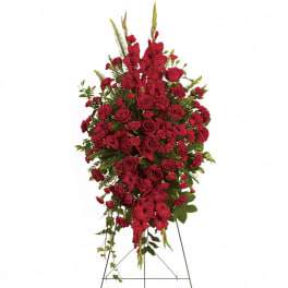 Tall standing spray of red roses and carnations on a metal easel