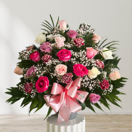 Large bouquet of pink and white roses with a pink ribbon