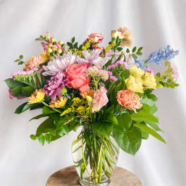 Mixed bouquet of pastel flowers in a clear glass vase