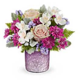 Pink and white flower arrangement in a glittery purple vase