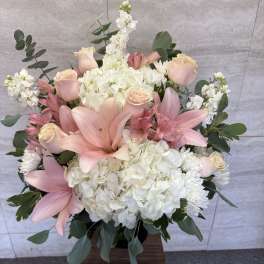 Pink lilies and roses with white hydrangeas in a vase