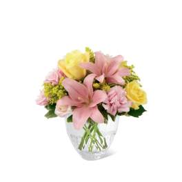 Pink lilies and yellow roses in a clear glass vase