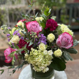Pink and cream roses with hydrangeas in a glass vase