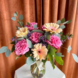 Pink roses and pale gerbera daisies in a glass vase