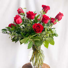 Red roses arranged in a clear glass vase